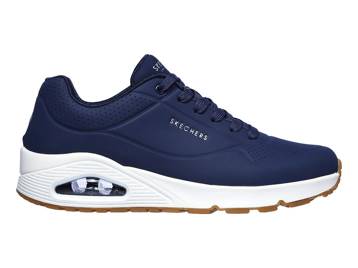 Tenis Skechers color azul marino con suela blanca y amortiguación visible en el talón.