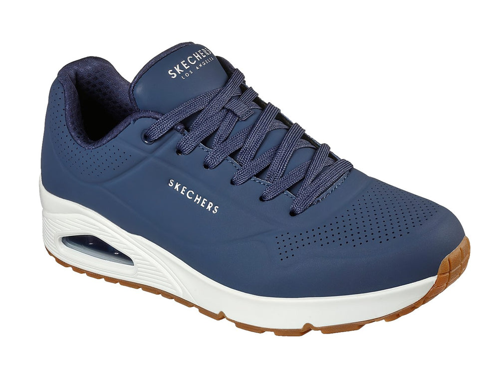 Tenis Skechers color azul marino con suela blanca y amortiguación visible en el talón.