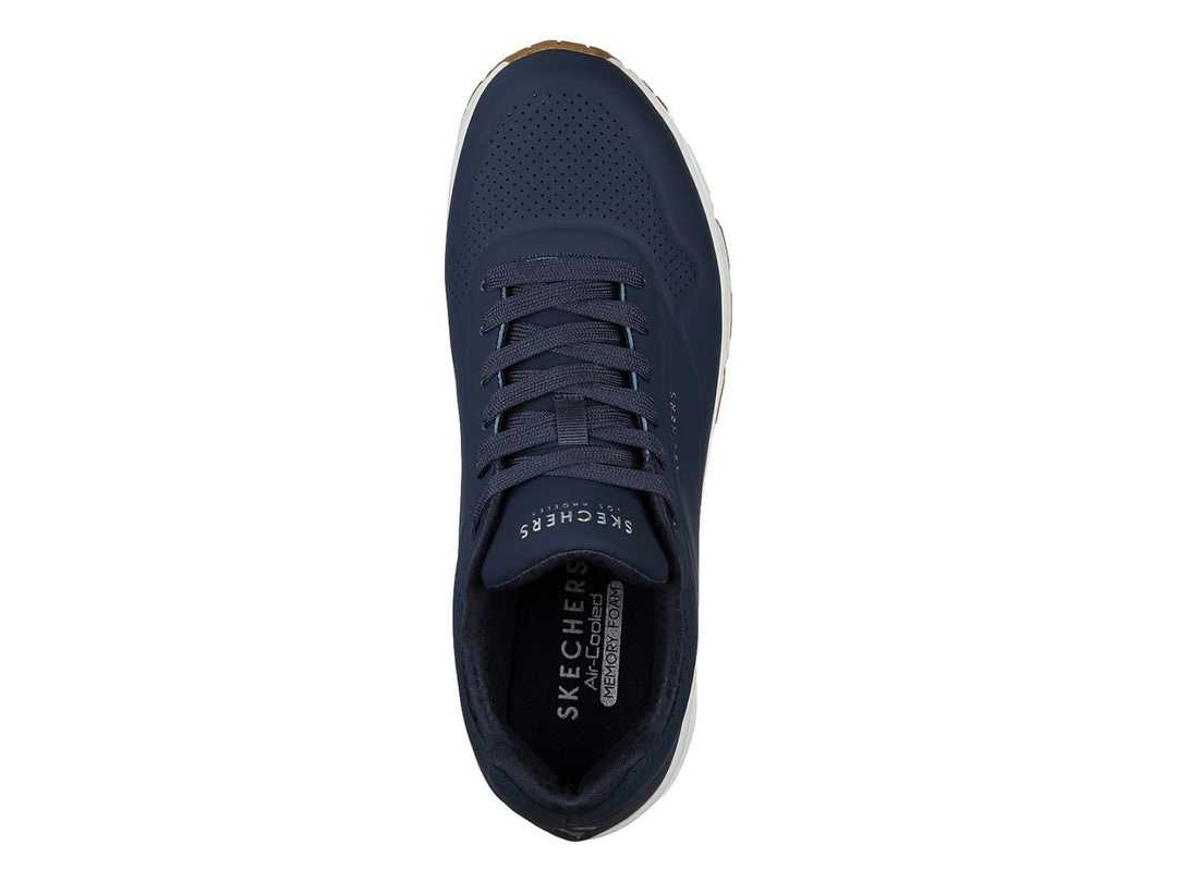 Tenis Skechers color azul marino con suela blanca y amortiguación visible en el talón.