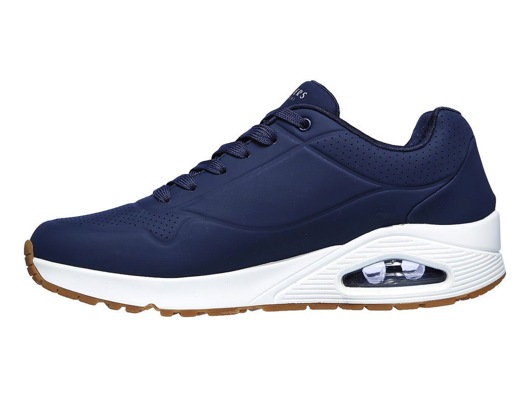Tenis Skechers color azul marino con suela blanca y amortiguación visible en el talón.