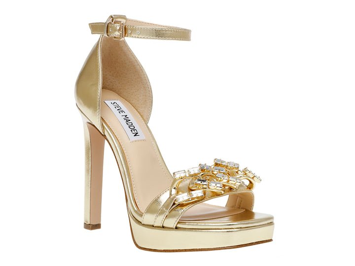 Sandalia dorada de Steve Madden con tacón alto, plataforma y detalles de pedrería en la parte frontal.