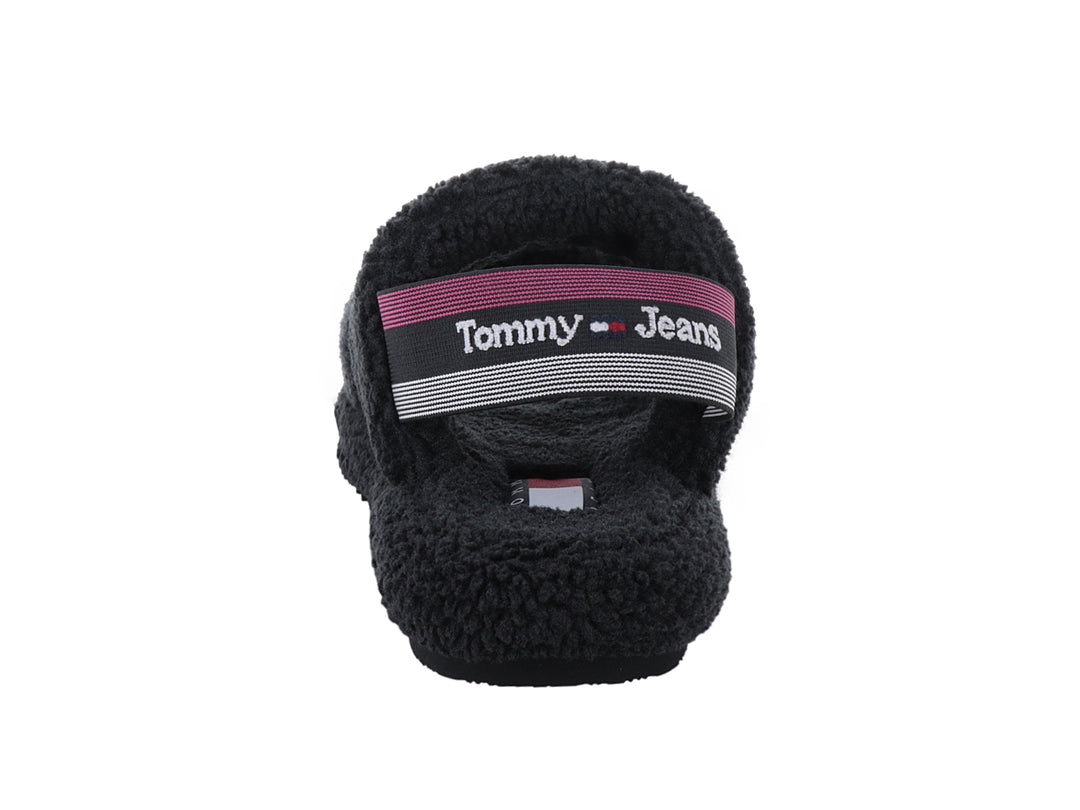 Sandalia negra de Tommy Hilfiger con textura de borreguito y suela dentada sobre fondo blanco.