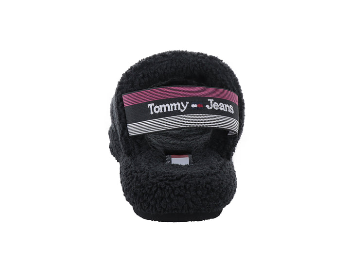 Sandalia negra de Tommy Hilfiger con textura de borreguito y suela dentada sobre fondo blanco.