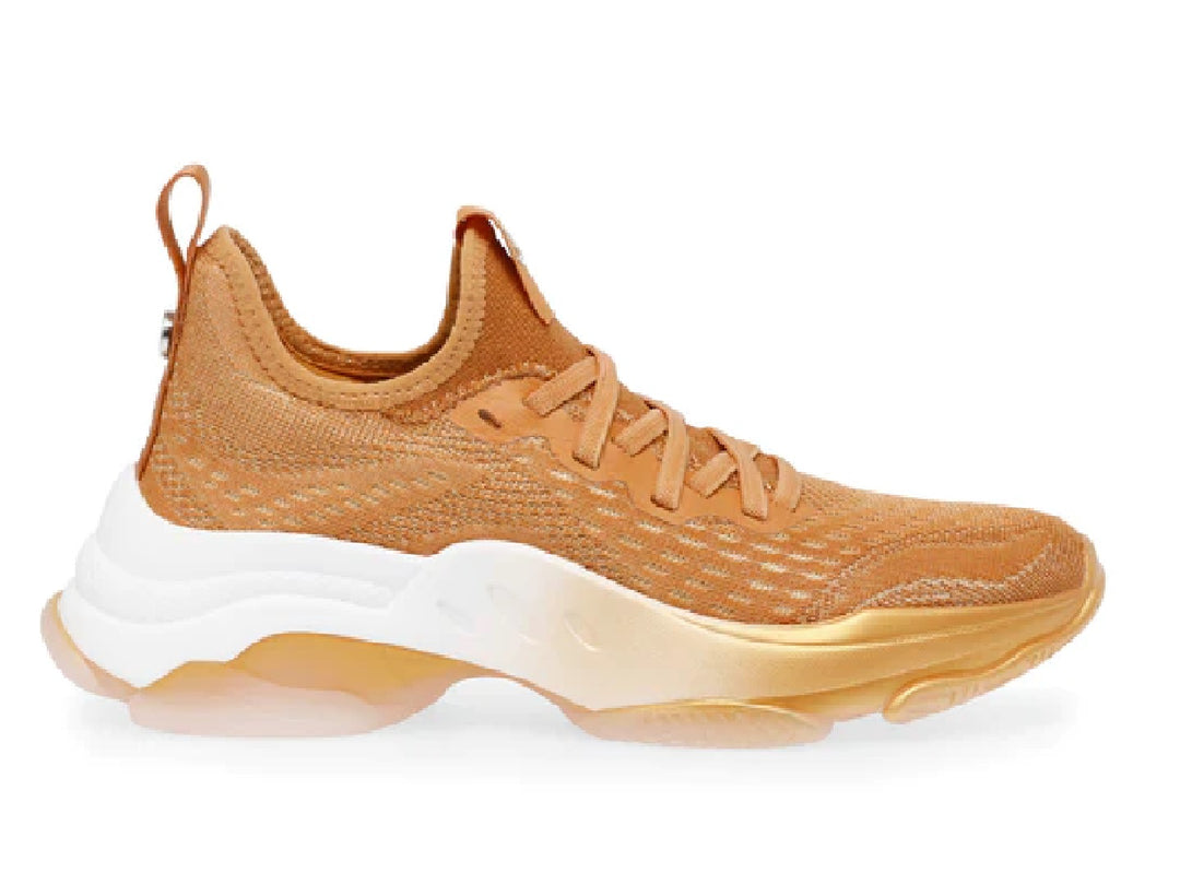 Tenis Steve Madden color naranja con tejido transpirable y suela blanca y translúcida.
