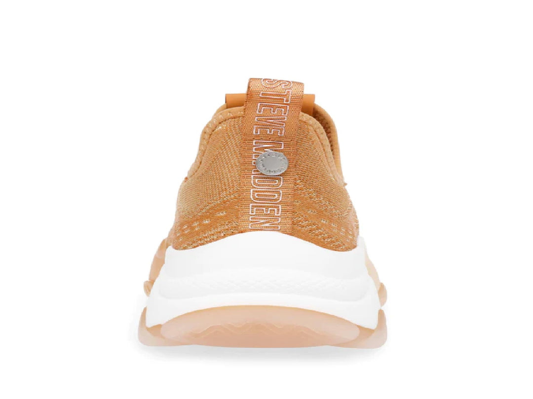 Tenis Steve Madden color naranja con tejido transpirable y suela blanca y translúcida.