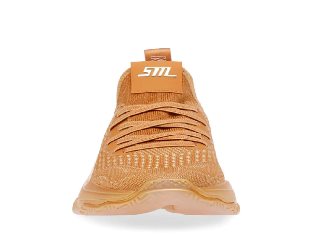 Tenis Steve Madden color naranja con tejido transpirable y suela blanca y translúcida.