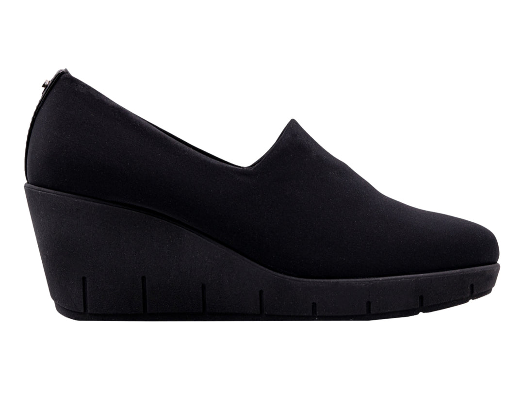 Zapato negro de cuña para mujer con diseño minimalista y suela ancha.