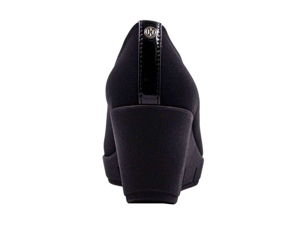Zapato negro de cuña para mujer con diseño minimalista y suela ancha.