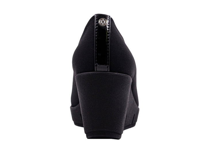 Zapato negro de cuña para mujer con diseño minimalista y suela ancha.