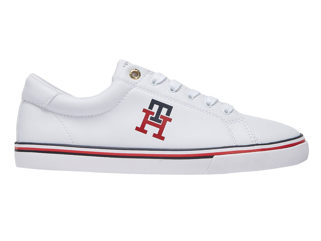 Tenis blancos Tommy Hilfiger con logotipo TH en rojo y azul y franja tricolor en la suela.