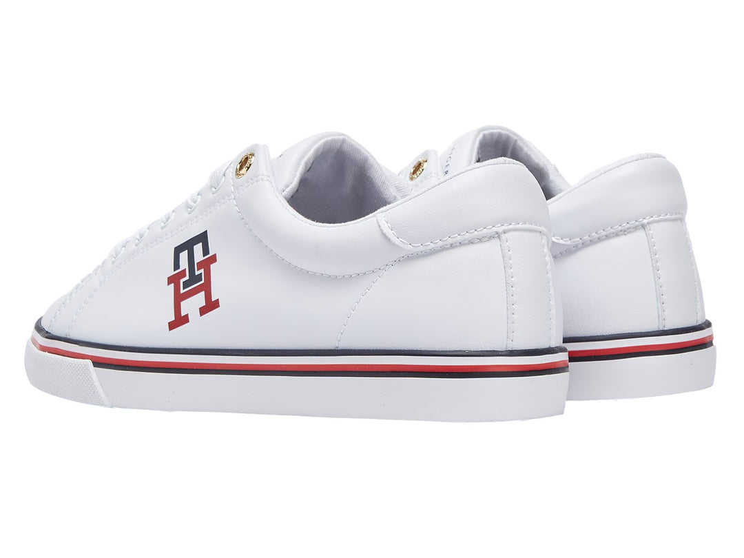 Tenis blancos Tommy Hilfiger con logotipo TH en rojo y azul y franja tricolor en la suela.