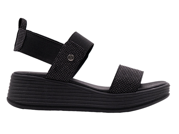 Sandalia de plataforma color negro con correas textiles y suela con relieve horizontal.