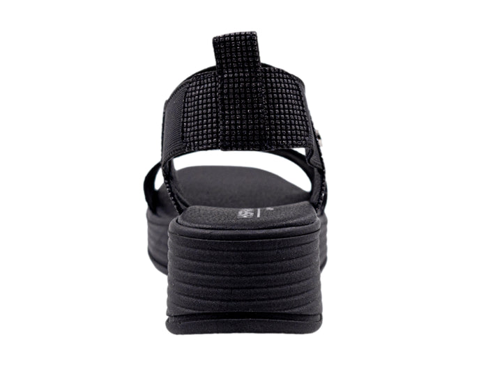 Sandalia de plataforma color negro con correas textiles y suela con relieve horizontal.