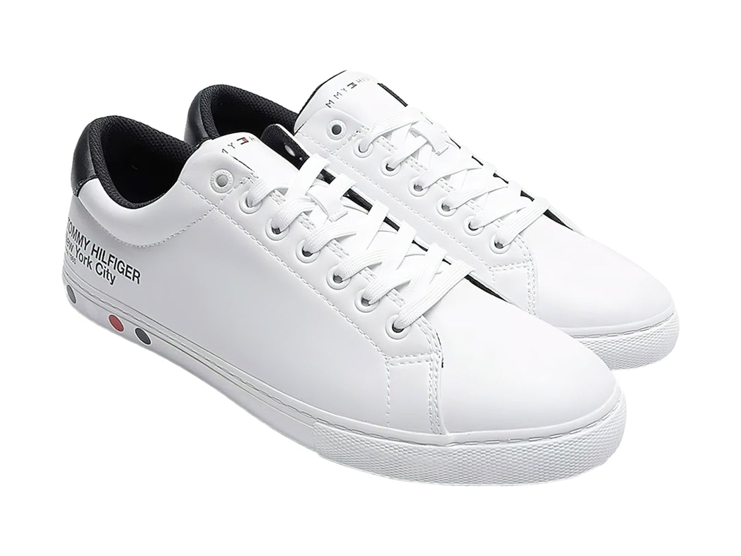 Tenis blancos de Tommy Hilfiger con detalle negro en el talón y suela blanca.