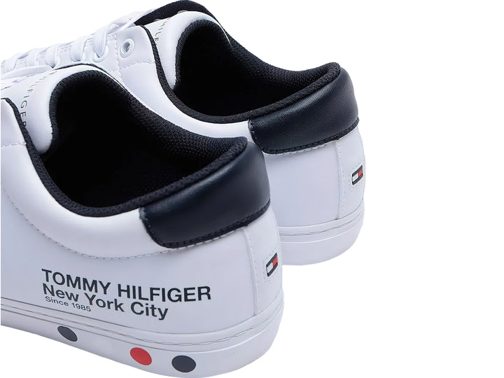 Tenis blancos de Tommy Hilfiger con detalle negro en el talón y suela blanca.