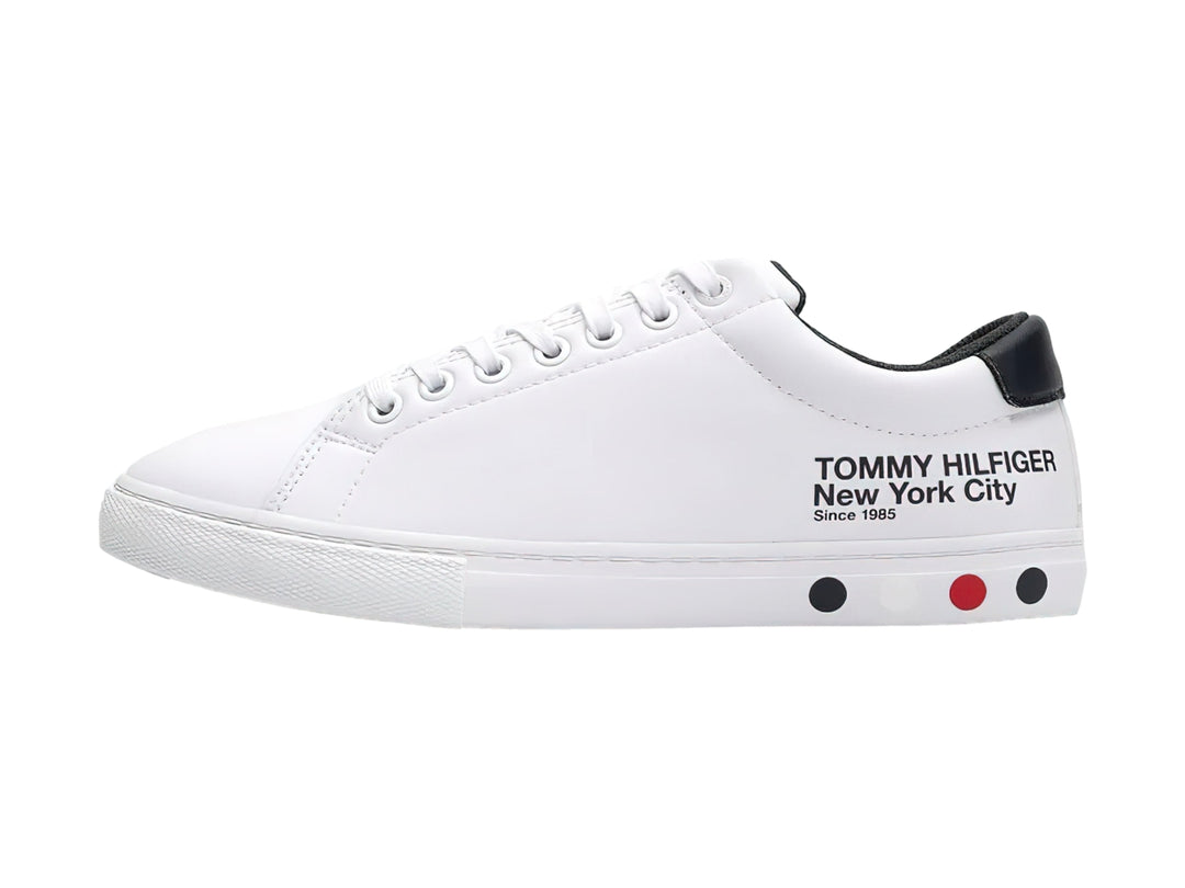 Tenis blancos de Tommy Hilfiger con detalle negro en el talón y suela blanca.