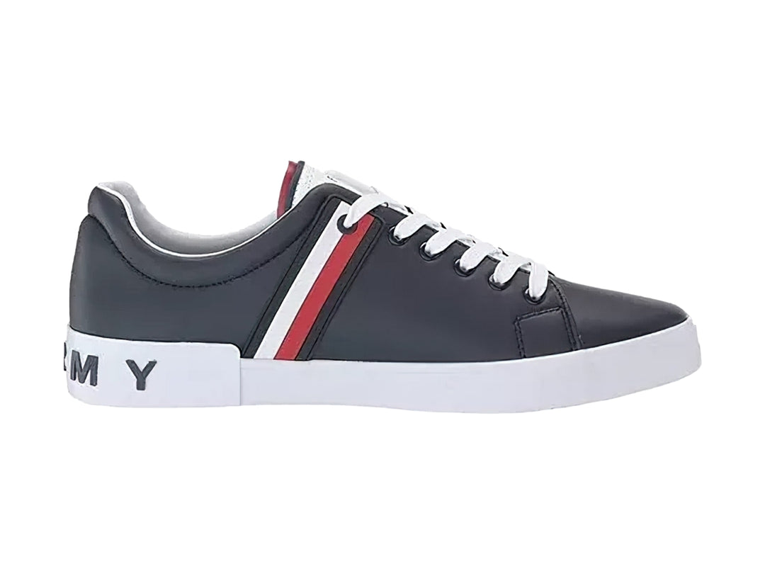 Tenis Tommy Hilfiger color negro con suela blanca y detalle de franja roja y blanca lateral.