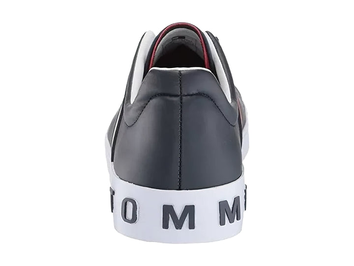 Tenis Tommy Hilfiger color negro con suela blanca y detalle de franja roja y blanca lateral.