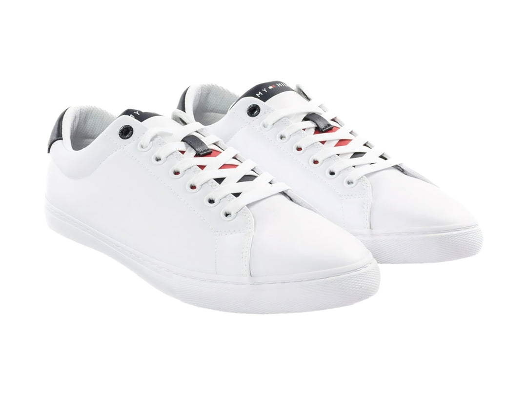 Tenis blancos de Tommy Hilfiger con detalles en azul marino en el talón y cordones.