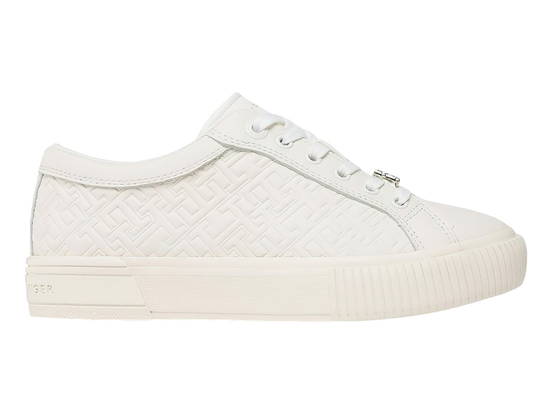 Tenis blancos de cuero Tommy Hilfiger con diseño de monograma grabado en el cuerpo y suela blanca.