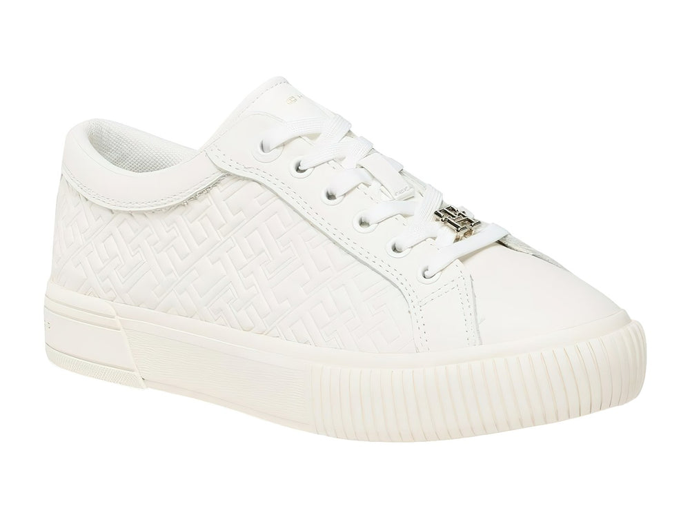 Tenis blancos de cuero Tommy Hilfiger con diseño de monograma grabado en el cuerpo y suela blanca.