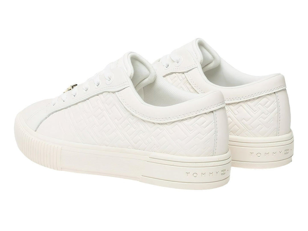 Tenis blancos de cuero Tommy Hilfiger con diseño de monograma grabado en el cuerpo y suela blanca.