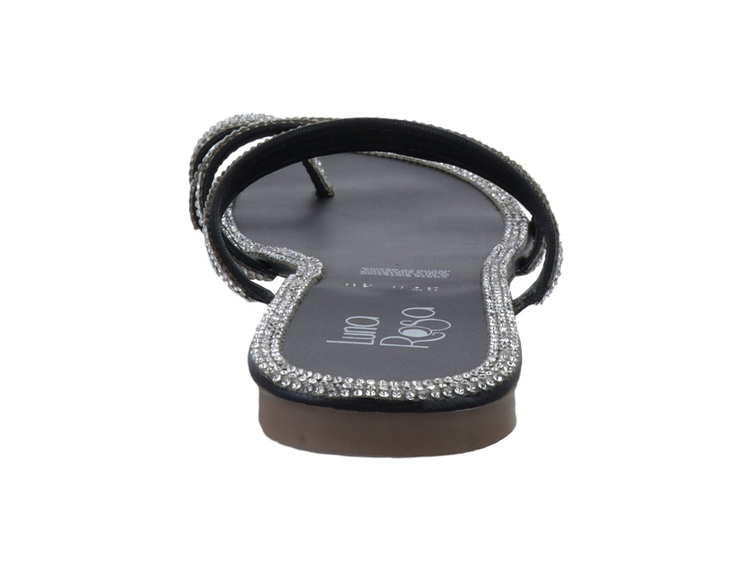 Sandalia plana color negro con tiras decoradas con piedras brillantes color plata.