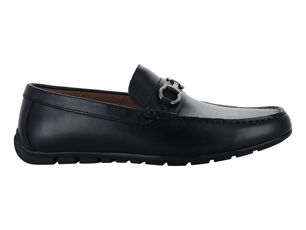 Zapato mocasín de cuero negro con herraje metálico plateado en la parte superior.