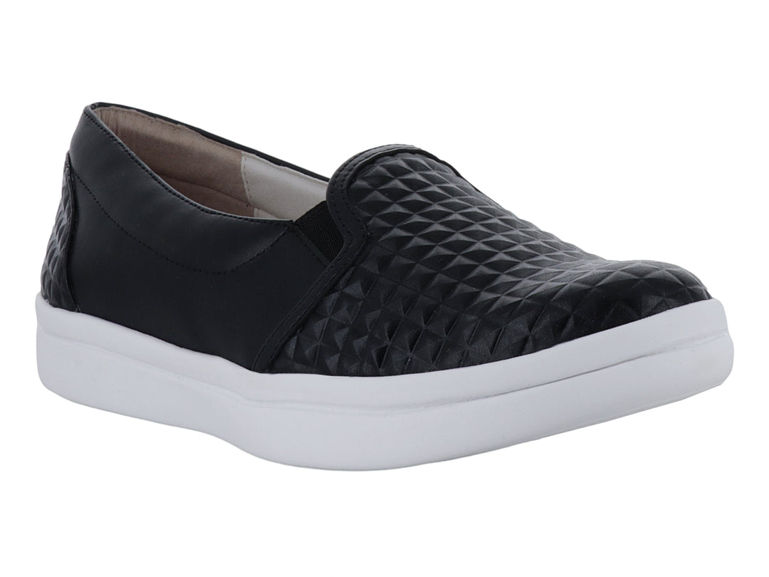 Zapato plano negro con suela blanca y detalles de textura geométrica en la punta y el talón.