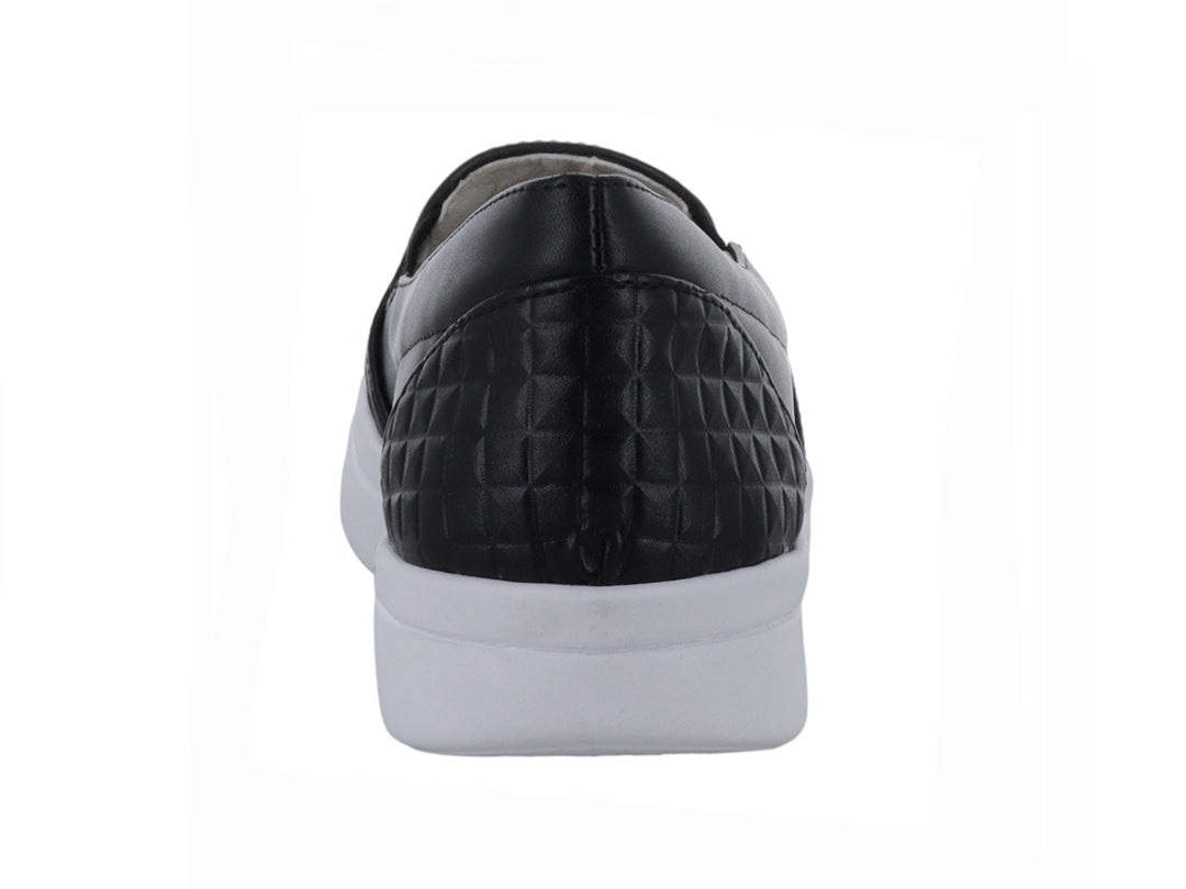 Zapato plano negro con suela blanca y detalles de textura geométrica en la punta y el talón.