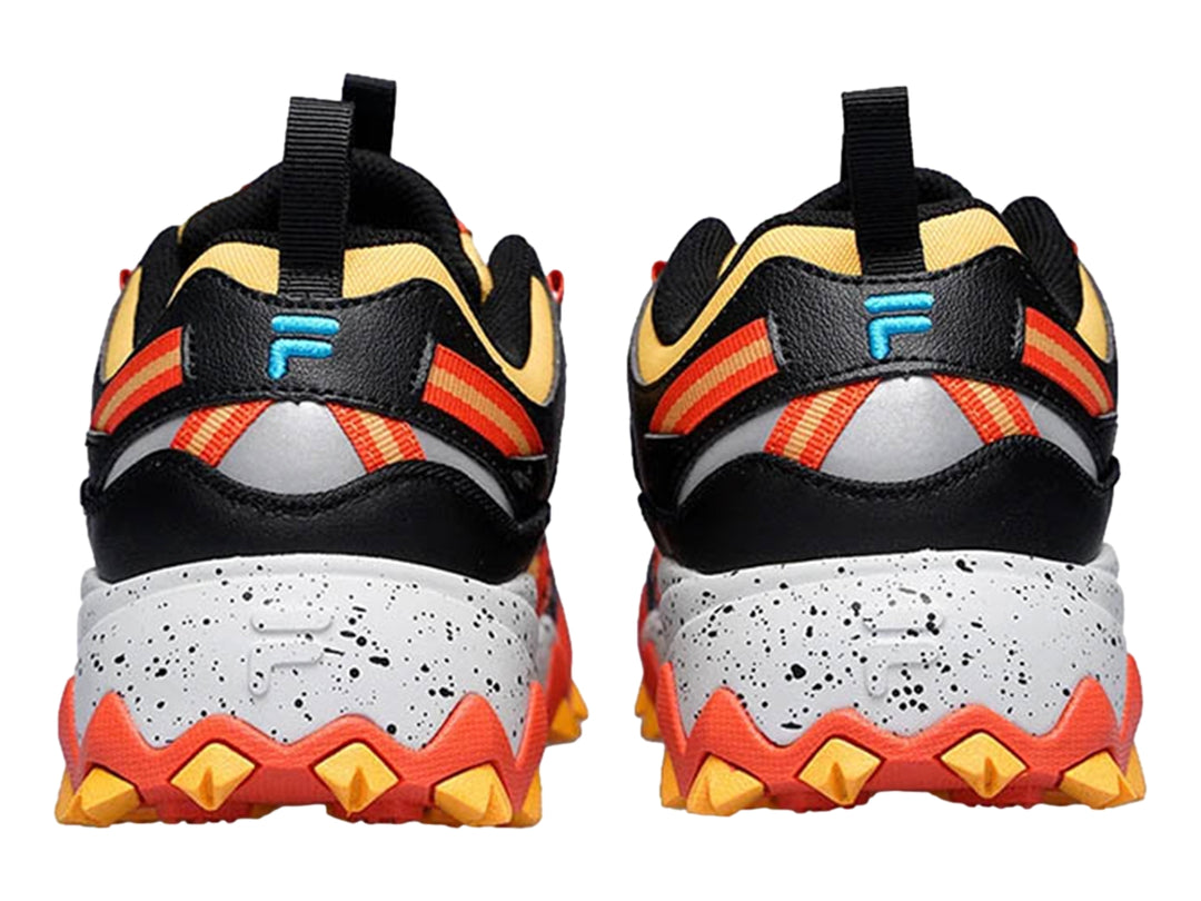 Tenis FILA Oakmont TR en colores amarillo, rojo y negro con suela blanca moteada y diseño robusto.