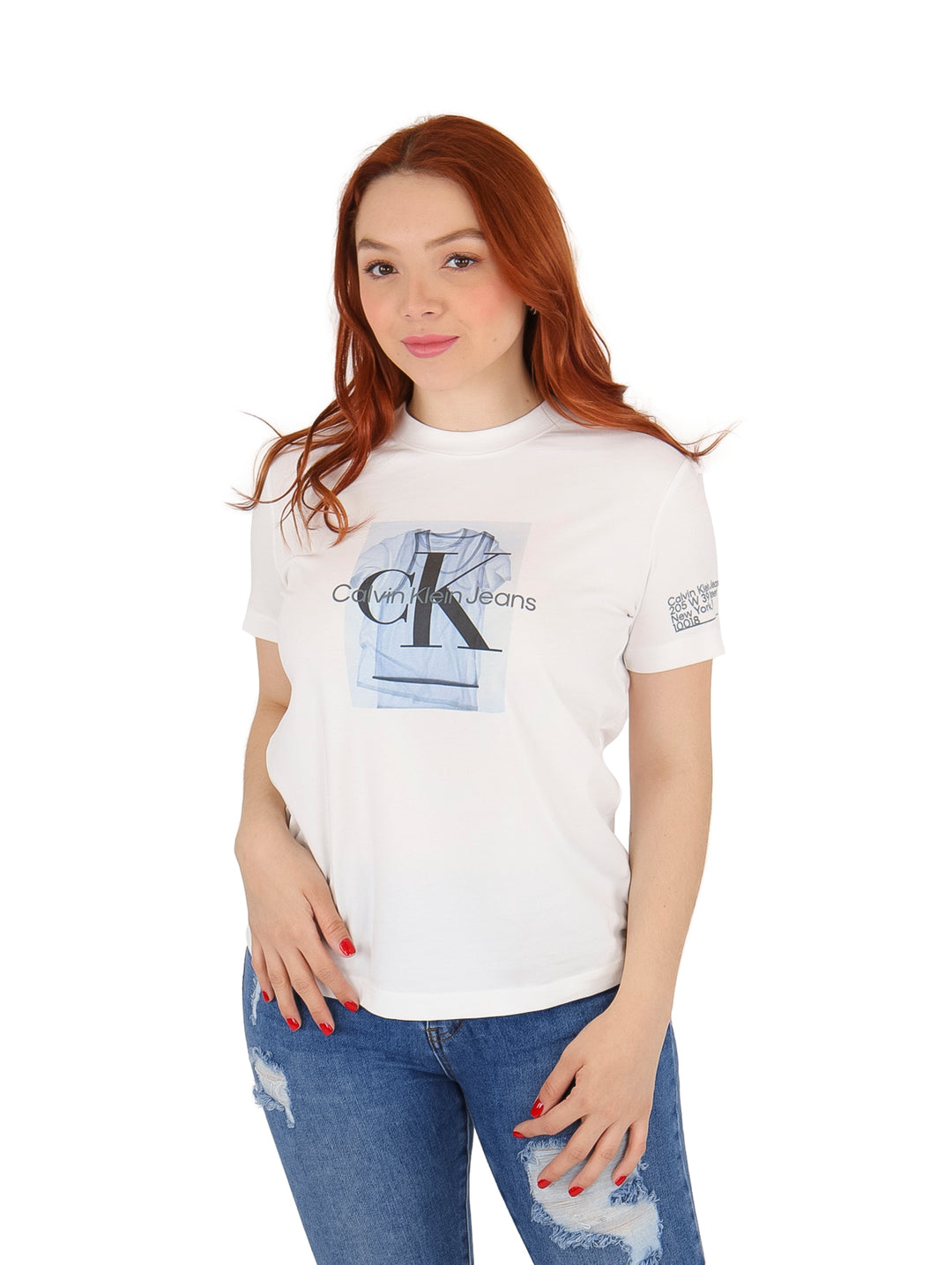 Mujer vistiendo playera blanca de manga corta con estampado central de Calvin Klein Jeans y jeans azules.