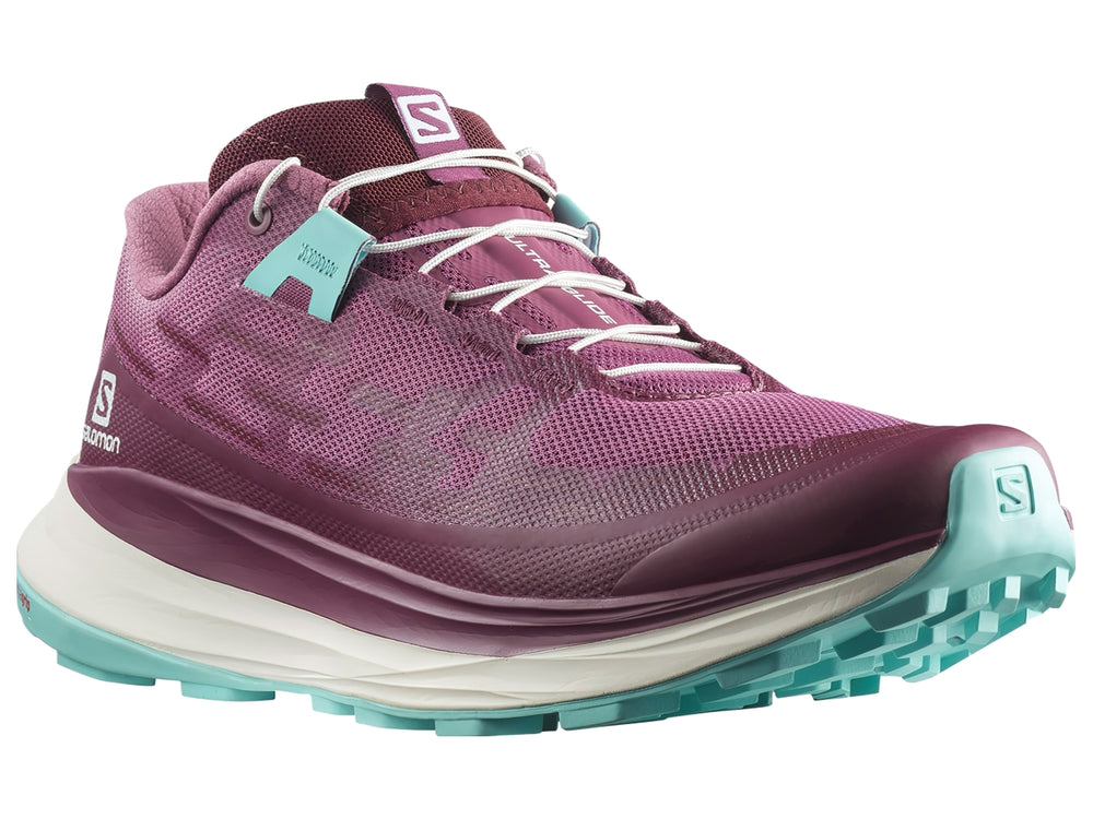 Tenis deportivos Salomon Ultra Glide en color tulipwood con suela blanca y detalles en turquesa.