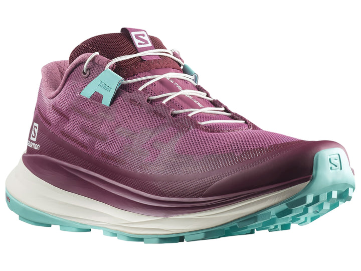 Tenis deportivos Salomon Ultra Glide en color tulipwood con suela blanca y detalles en turquesa.