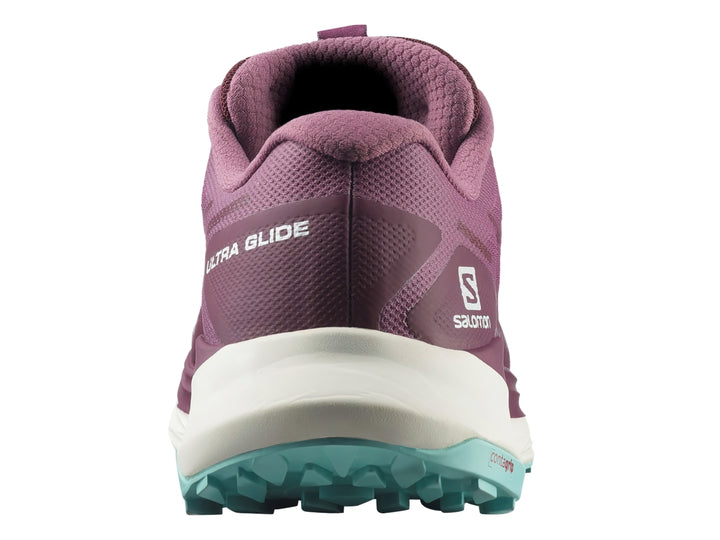 Tenis deportivos Salomon Ultra Glide en color tulipwood con suela blanca y detalles en turquesa.
