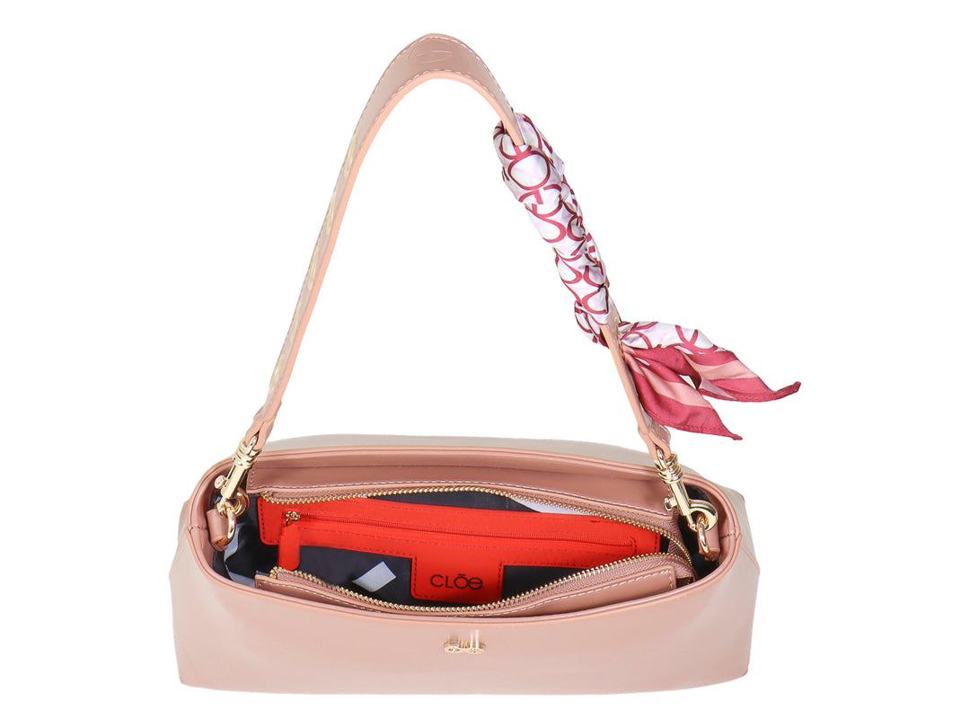 Bolsa de hombro Cloe color rosa pathe con un pañuelo decorativo rojo y blanco en la correa.