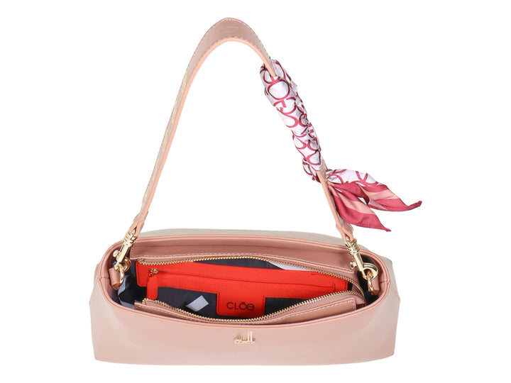 Bolsa de hombro Cloe color rosa pathe con un pañuelo decorativo rojo y blanco en la correa.