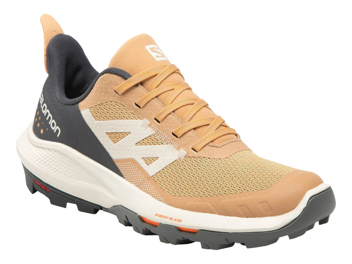 Tenis deportivos Salomon Outpulse en colores beige, gris oscuro y detalles naranjas con suela blanca y negra.