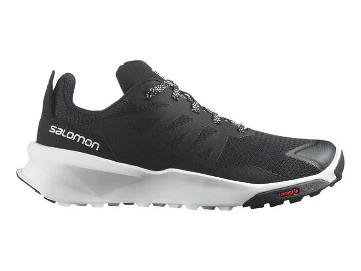 Zapato deportivo Salomon Patrol color negro con suela blanca y detalles en rojo.