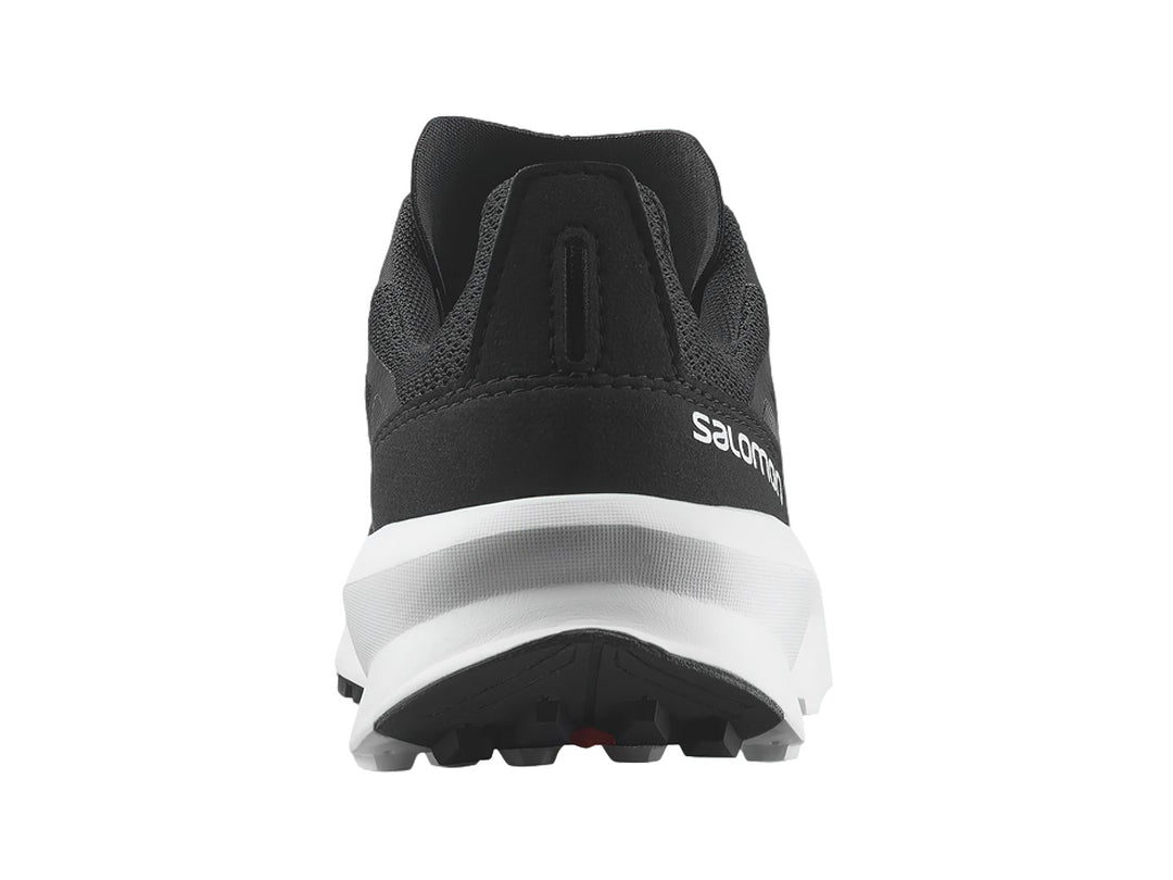 Zapato deportivo Salomon Patrol color negro con suela blanca y detalles en rojo.