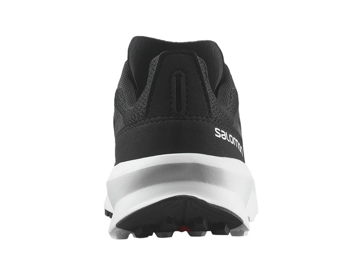 Zapato deportivo Salomon Patrol color negro con suela blanca y detalles en rojo.