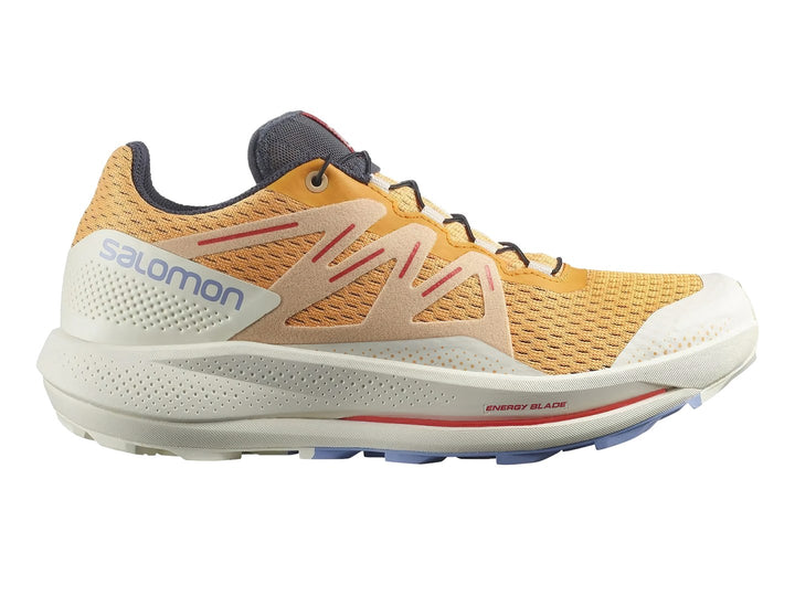 Tenis Salomon Pulsar Trail color amarillo y blanco con detalles rojos y suela blanca robusta.