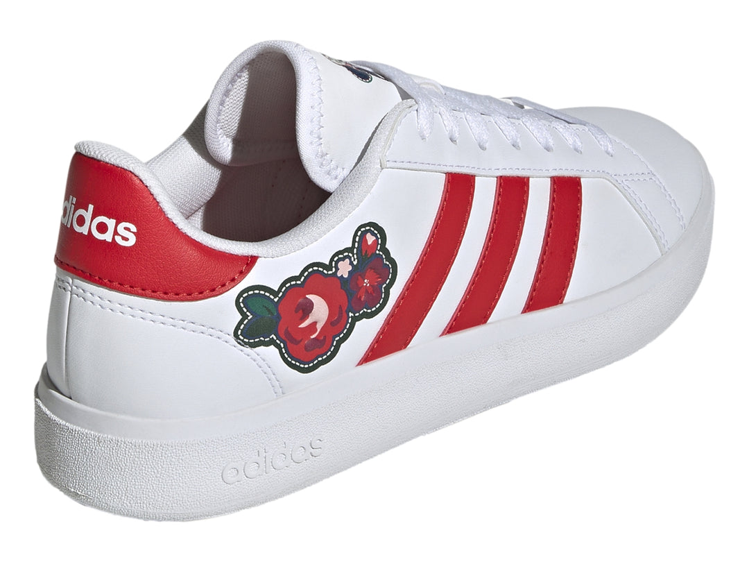 Tenis Adidas blancos con tres rayas rojas y un detalle floral en el lateral.
