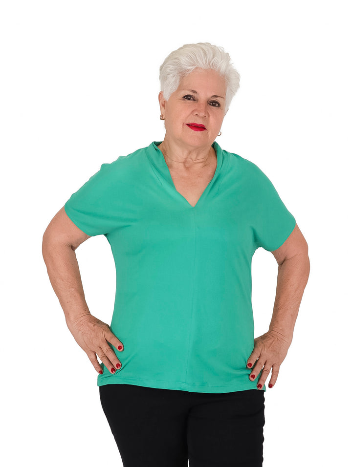 Mujer vistiendo una blusa casual de color verde con cuello en V y manga corta.