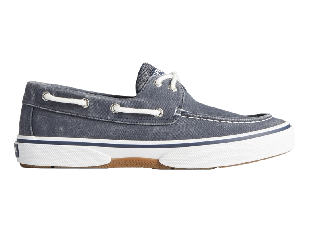 Zapato náutico Sperry de tela azul marino con suela blanca y cordones blancos.