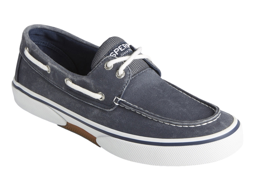 Zapato náutico Sperry de tela azul marino con suela blanca y cordones blancos.