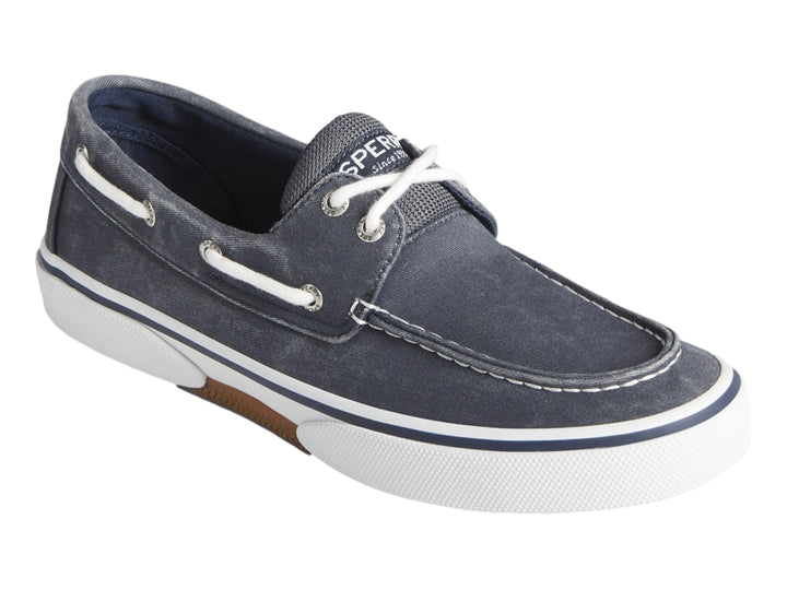 Zapato náutico Sperry de tela azul marino con suela blanca y cordones blancos.