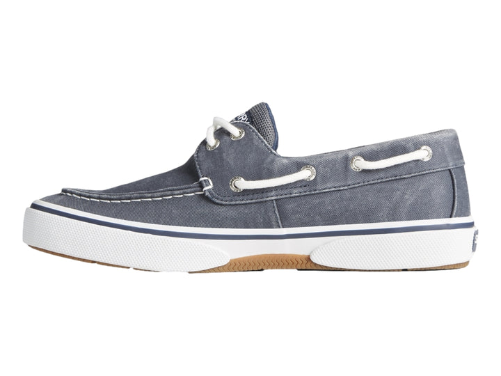 Zapato náutico Sperry de tela azul marino con suela blanca y cordones blancos.