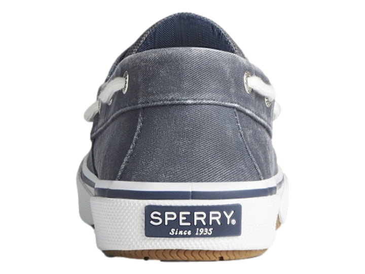 Zapato náutico Sperry de tela azul marino con suela blanca y cordones blancos.