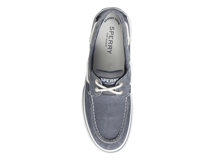 Zapato náutico Sperry de tela azul marino con suela blanca y cordones blancos.